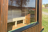 Familjeoasen I Skandinavisk bastu i trä med plåtdetaljer